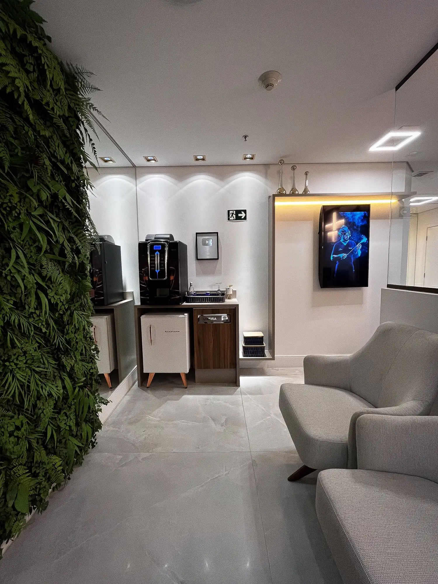 Espaço de espera com café e parede verde