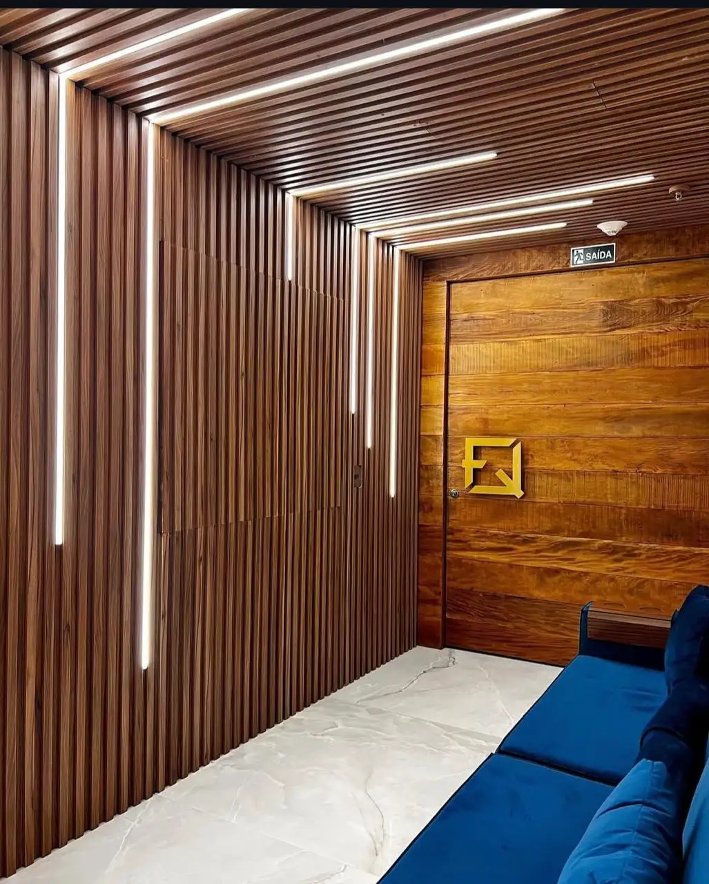 Corredor com painel de madeira e o monograma da marca